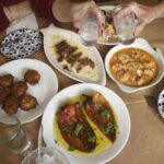 a table with plates of food and glasses