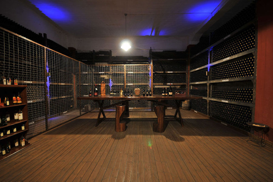 stacked bottles on top of each other in the storage lockers at illuminated 'Vaeni Naoussa' cellar