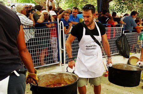 men carrying bronze cauldrons with food at Oxilithos Festival, Euboea, Greece