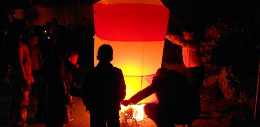 children lighting a Hot-Air Balloons at Easter at Arkadia, Greece by night