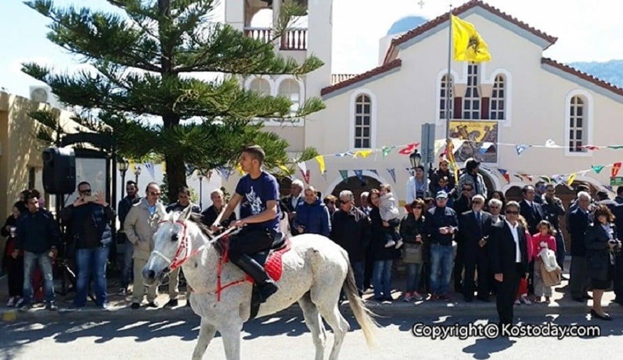 Man running a white horse at Festival of Aghios Georgios (Saint George) at Kos, Pyli region, Greece and people watching from the side