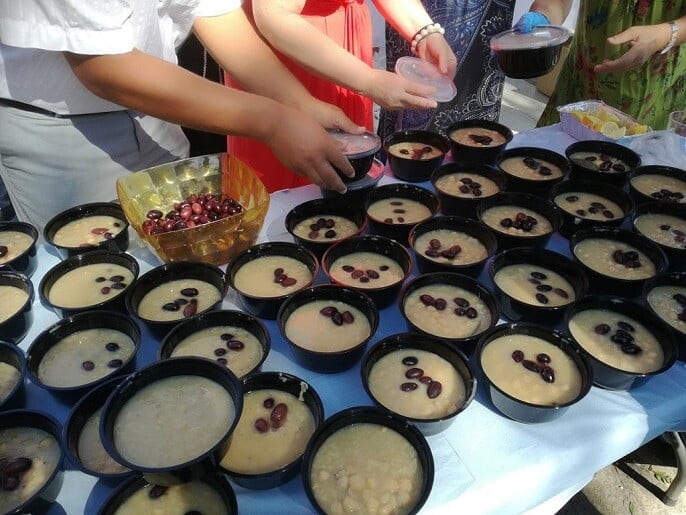 women prepere bowls with 'revithada' soup at Festival for the Raising of the Holy Cross church, at Paros, Ageria, Greece