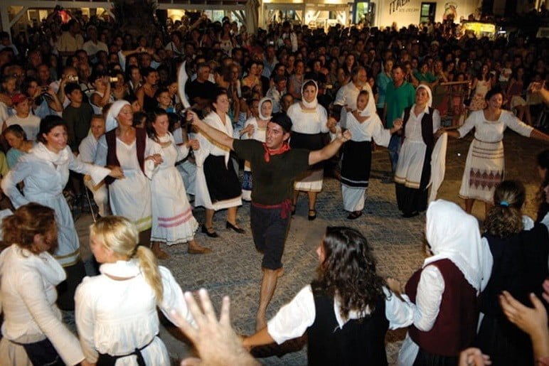 people dressed with folklore cloths participate at Festival of the Karavola at Paros, Lefkes, Greece and dancing in circle by night