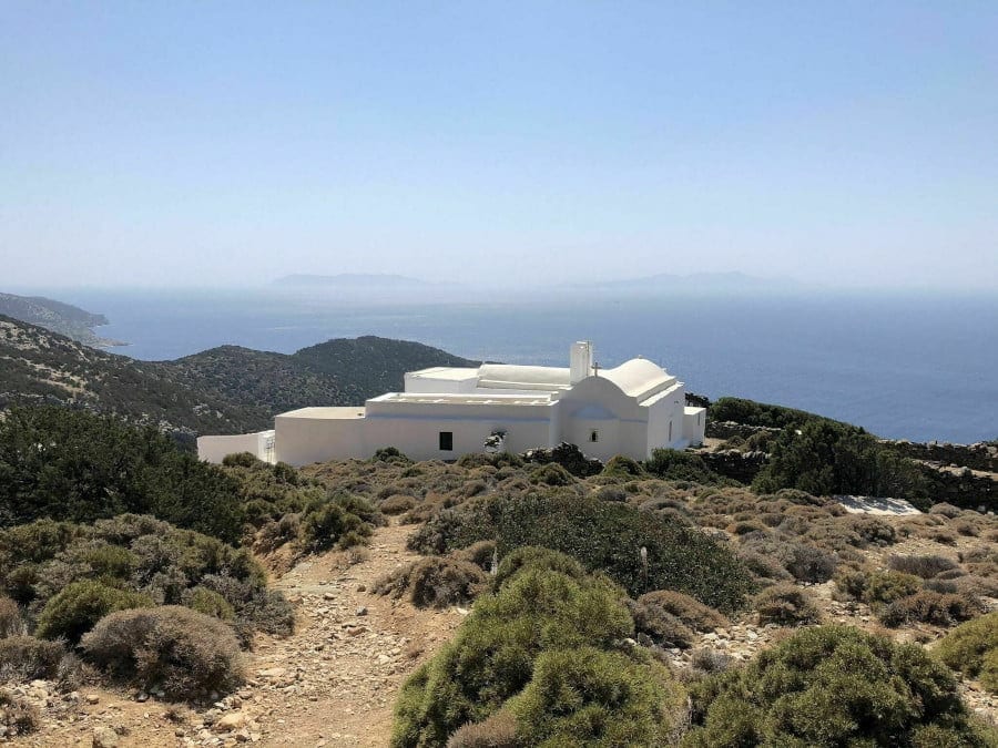 Church of Virgin Toso Nero on the hill and surrounded by treess and the sea in the background, commemorate festival of her birth at Sifnos, Greece