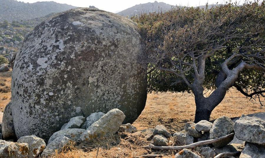spherical rock in nature and tree at Tinos, Volakas surrounded by others small rocks