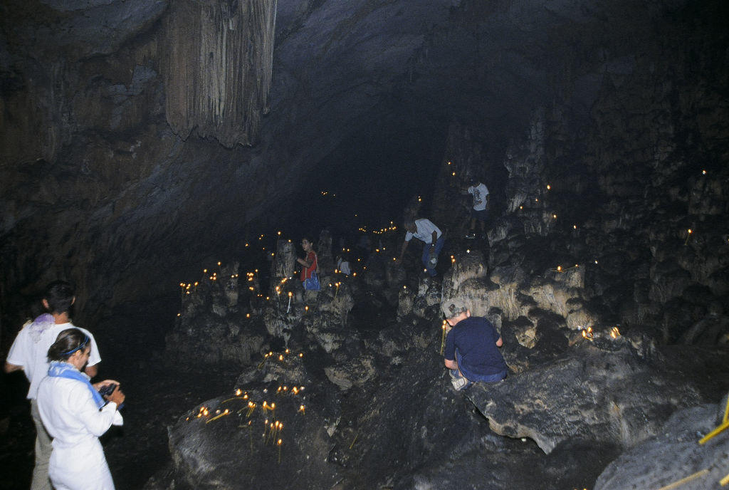 people with candles inside of cave at the Church of St. John the Baptist commemorate festival of her birth at Herakleia, Greece