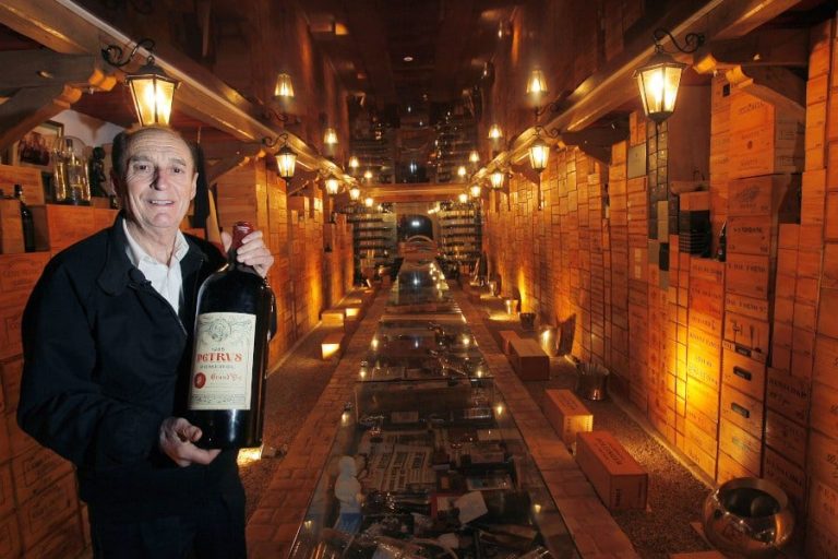 man smiling at the camera and holding a big bottle of champagne at The ‘Louvre of Wine’ Museum