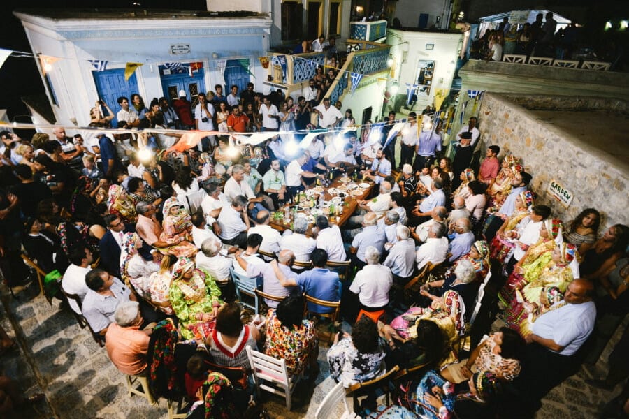 People sitting outside at entrance of the church of the Assumption of Virgin Mary and commemorate festival of her birth at Olympos, Greece