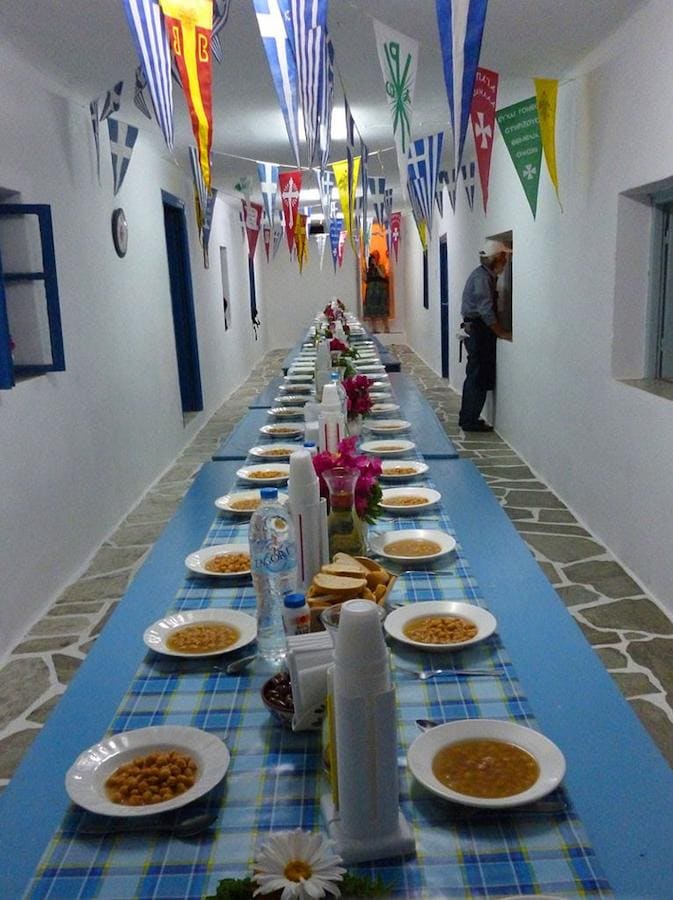 long table with plates with revithada at church of Panagia of Chrisopigi - Gastronomy Tours