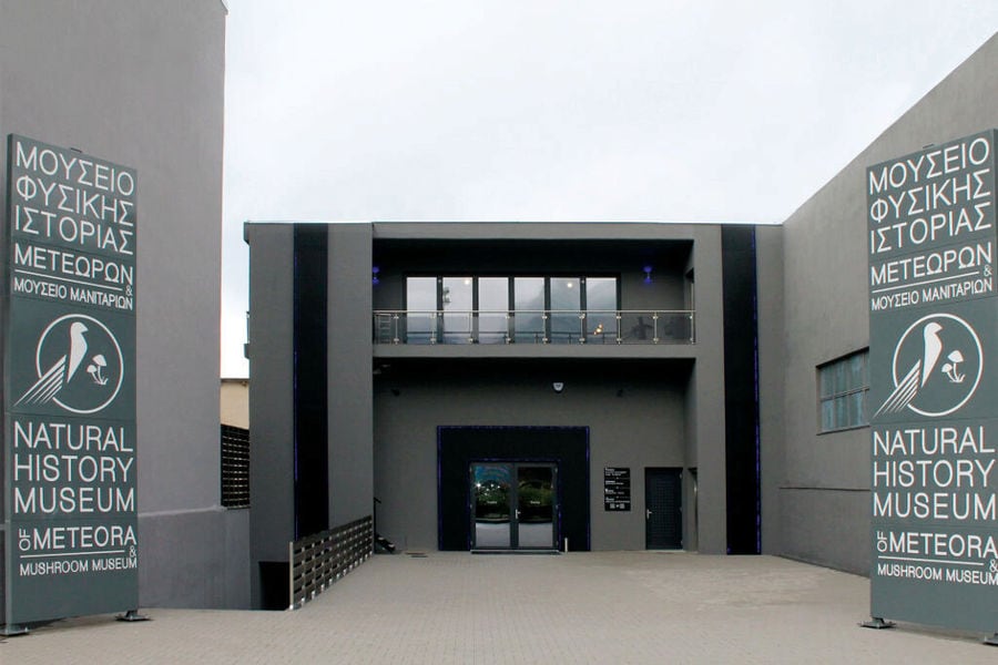 entrance with signs on both sides that says 'NATURAL HISTORY MUSEUM METEORA'