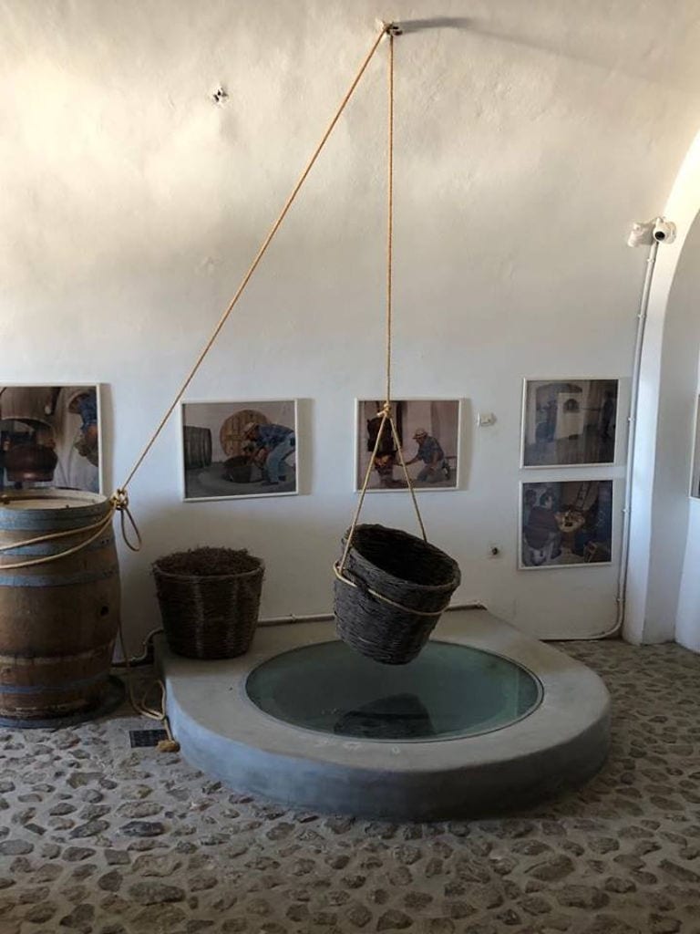 wicker basket tied with a barrel from the wall of Tselepos Winery forming a balance