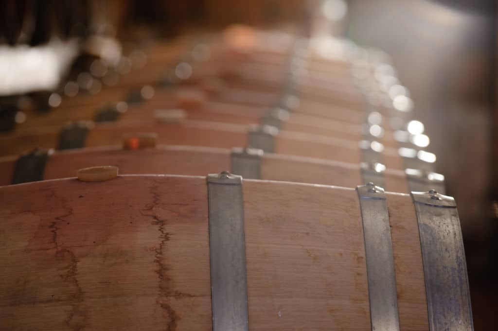 lying wooden barrels in a row at ‘Tsililis’ cellar that recognized with many awards|
