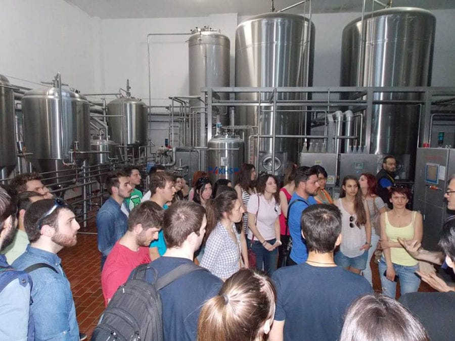 tourists listening to a man giving a tour at 'Vergina Beer' plant