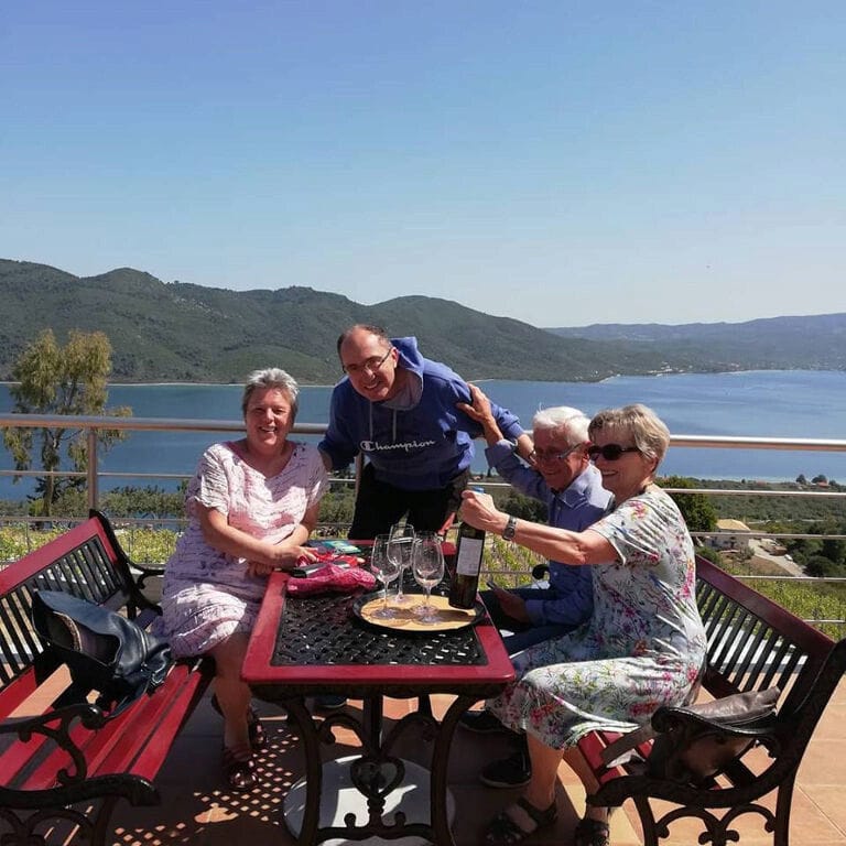 two couples sitting and tasting Vriniotis Winery wines and smiles happily at the camera