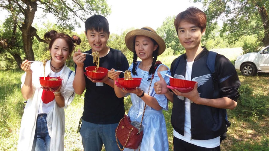 Korean tourists eating pasta on red bowls in nature at 'Mushroom Museum Meteora'