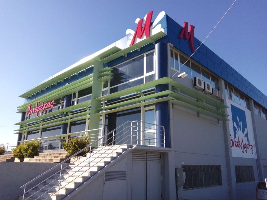 corner of Mandrekas Greek Yogurt manufacture that says "M" in upper part of the walls