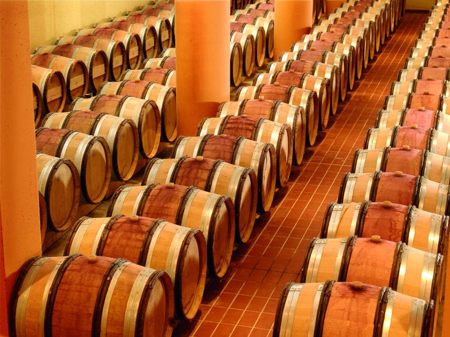 wine wood barrels on top of each other in a row at Nemeion Estate cellar