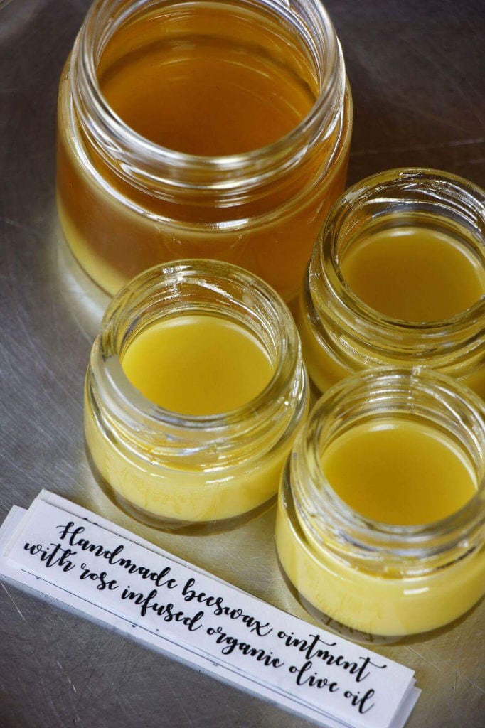 jars with beeswax from 'Gea Olympou' and a small paper that says ‘handmade beeswax ointment with rose infused organic olive oil’