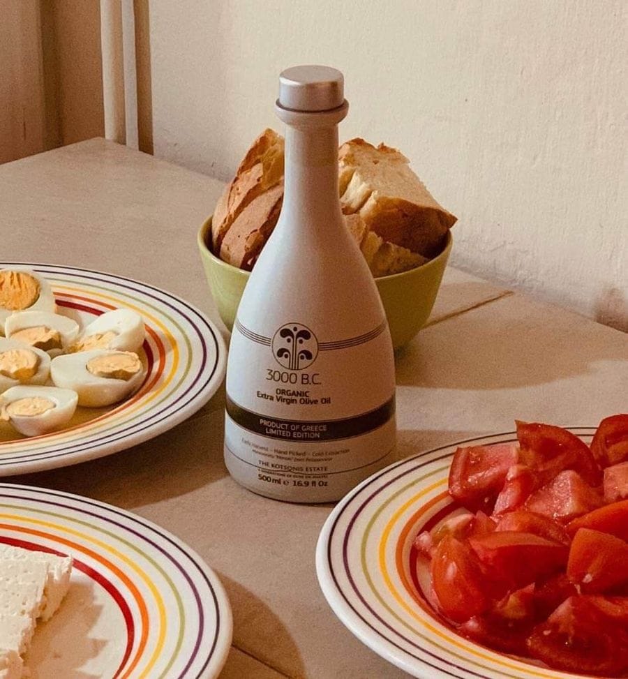 A table set for olive oil tasting with olive oil in the centre and snacks