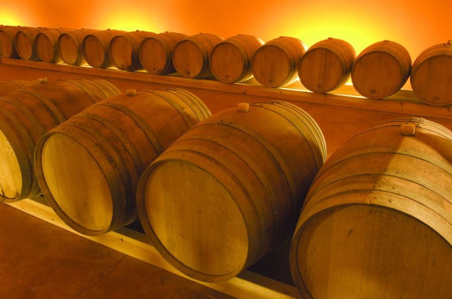 wine wood barrels on top of each other in a row at 'Domaine Zacharioudakis' cellar