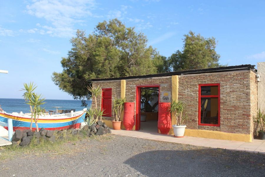 Gaia Wines Santorini building on the seafront and a little boat is stored next door