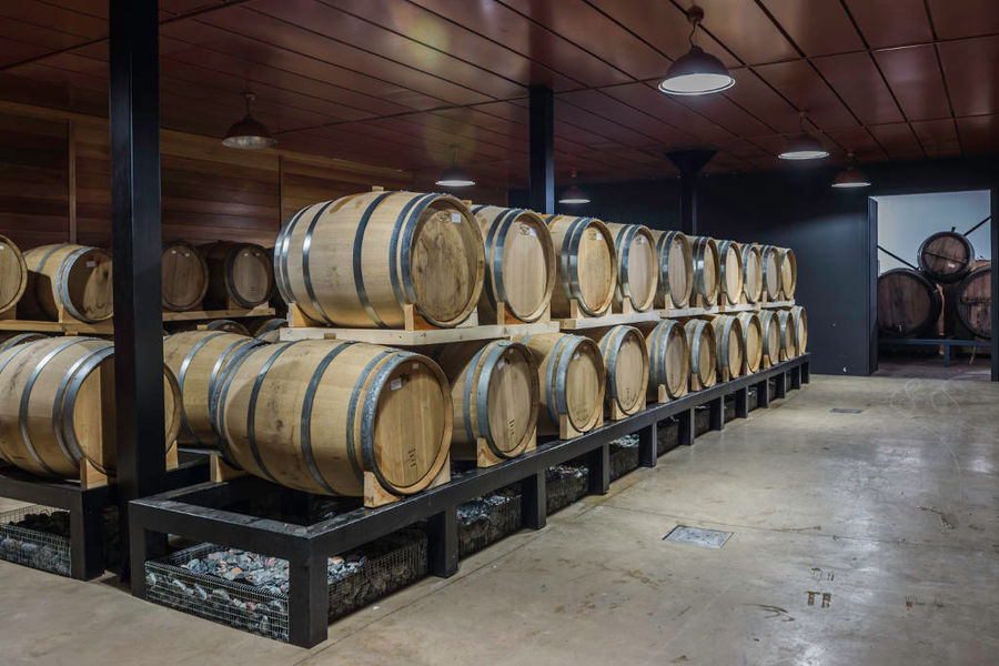 wooden barrels on top of each other at Callicounis Distilleries cellar