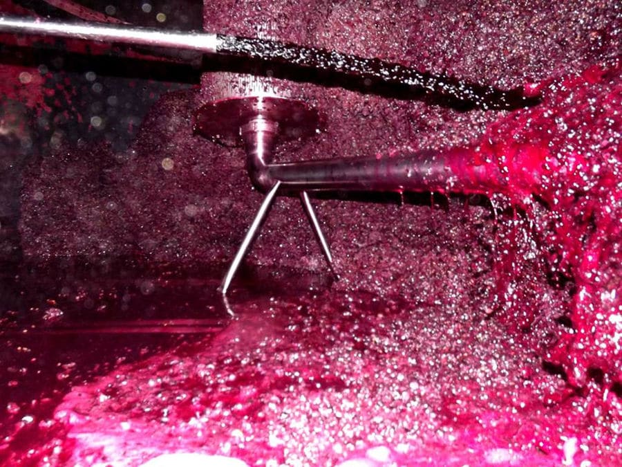 red wine 'must' flowed into grape press machine at'Domaine Zacharioudakis' facilities