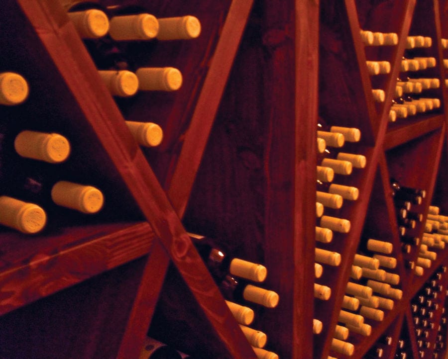 wine bottles on top of each other in the storage lockers at 'Kourkoulou Winery' cellar