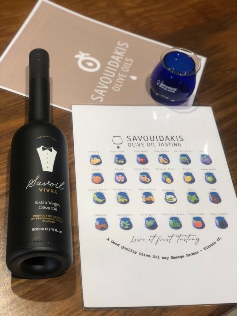 A bottle of olive oil, a blue glass and olive oil tasting instructions