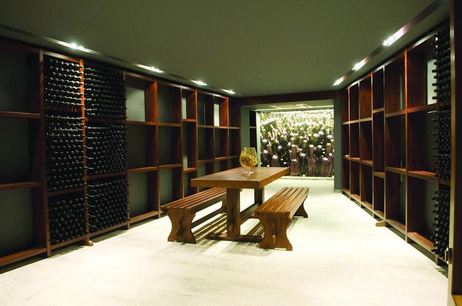 wood table with benches with wine bottles in the storage lockers on the both sides at 'Domaine Zacharioudakis' cellar