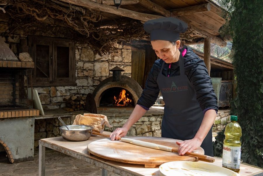 a skilled woman in a black cooking uniform is skillfully preparing the dough for the pie, showcasing her culinary expertise and passion.