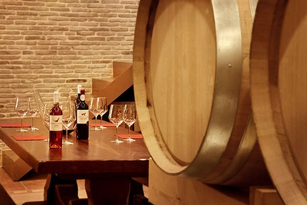 Wine cellar with barrels and a table set for wine tasting