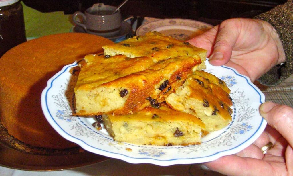 Man holding plate with pieces of ‘Budino’ means pie with semolina