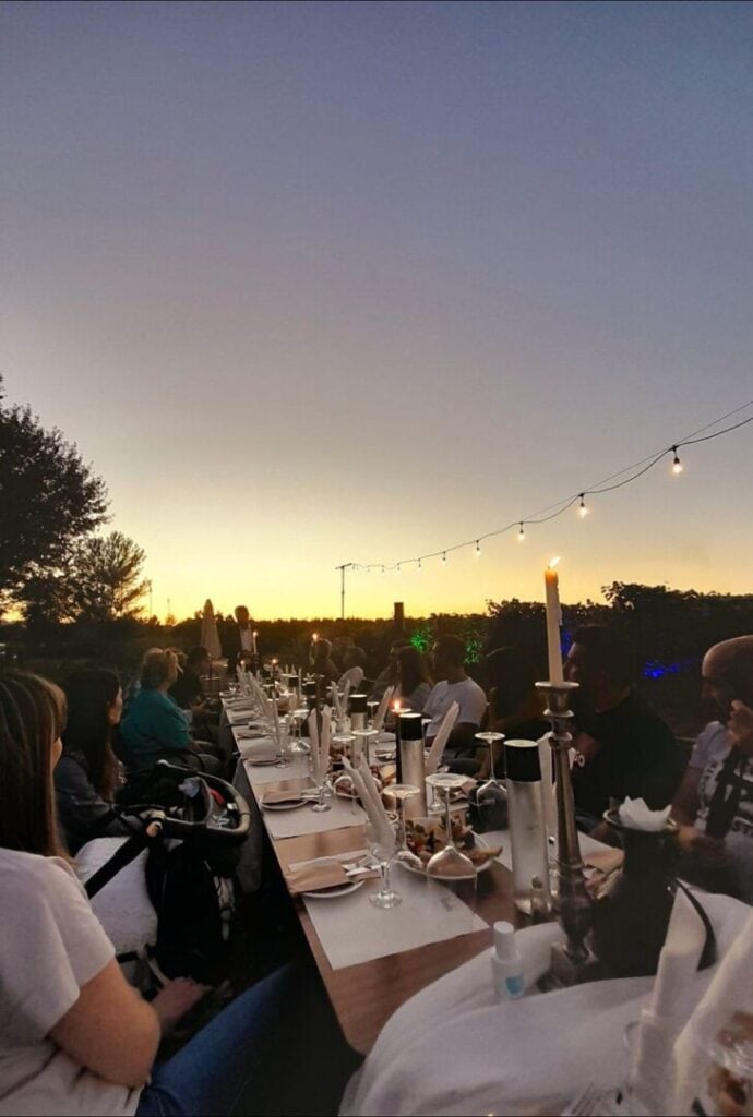 Visitors enjoy the wine tasting process at a large table with candles