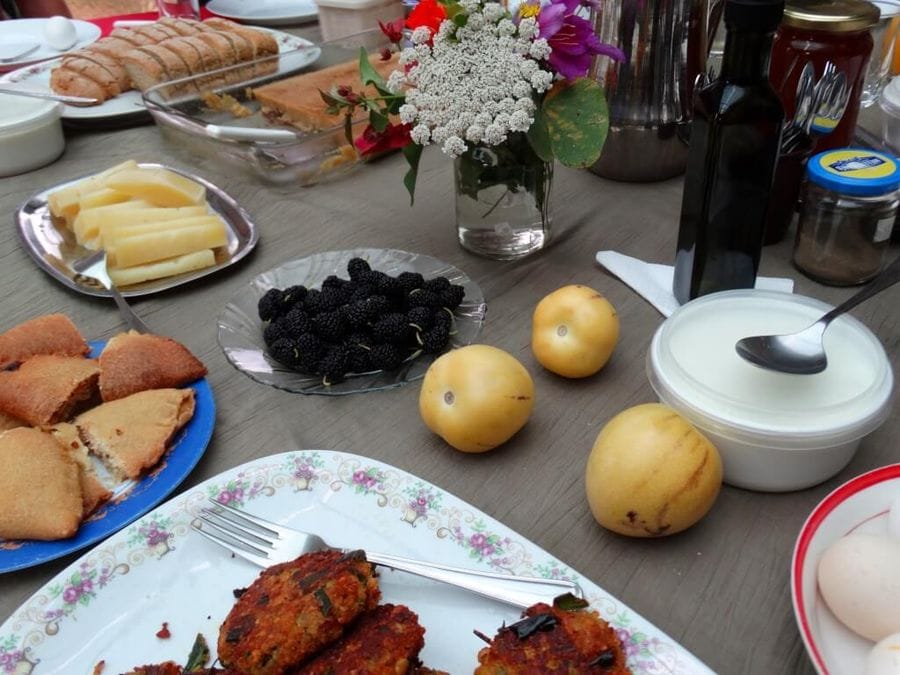 Table adorned with grey , featuring eggs, bread, zucchini balls, omelette.