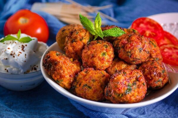 Close-up of bowl with Greek ‘Domatokeftedes’ means tomato meat balls fried in oil and green herb on top