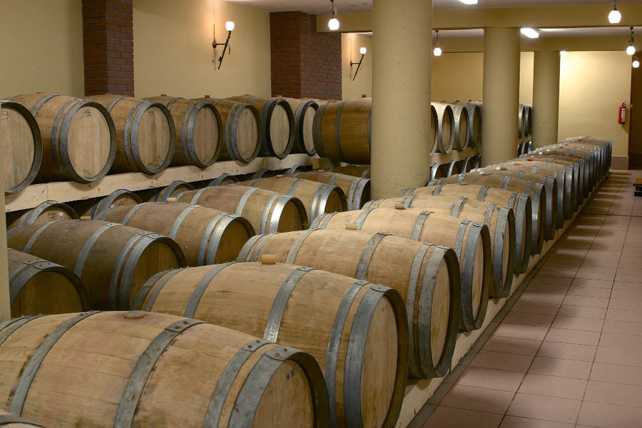 lying wine wood barrels on top of each other at illuminated 'Foundi Estate' cellar