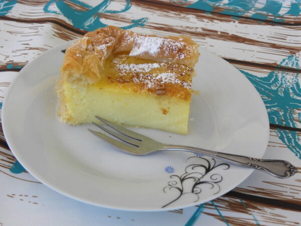 Close-up of plate with a piece of Greek ‘Galatopita’ means milk pie and a fork beside it