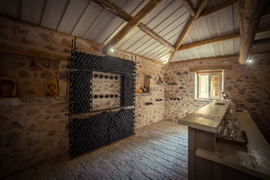 stacked bottles on top of each other on the stone wall at Goumas Estate cellar