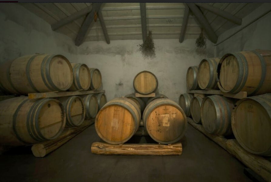 wine barrels on top of each other on the wood panels at Goumas Estate cellar