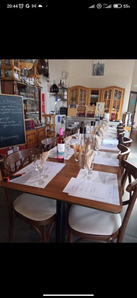 Kappa Winery's restaurant with a table set for wine tasting and shelves with wine bottles
