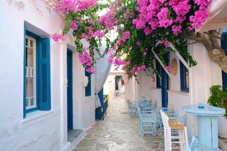 small payment street at Kythnos with white houses with blue windows on the both sides