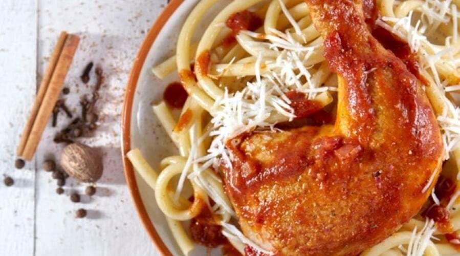 plate with spaghetti pasta served with chicken with tomato sauce represent Gastronomy of Euboea