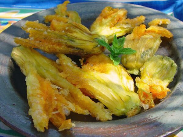 close-up of plate with ‘Kolokithokorfades’ means fried zucchini blossoms