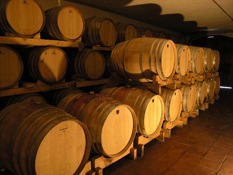 wine wood barrels on top of each other in a row at Lafkiotis Winery cellar