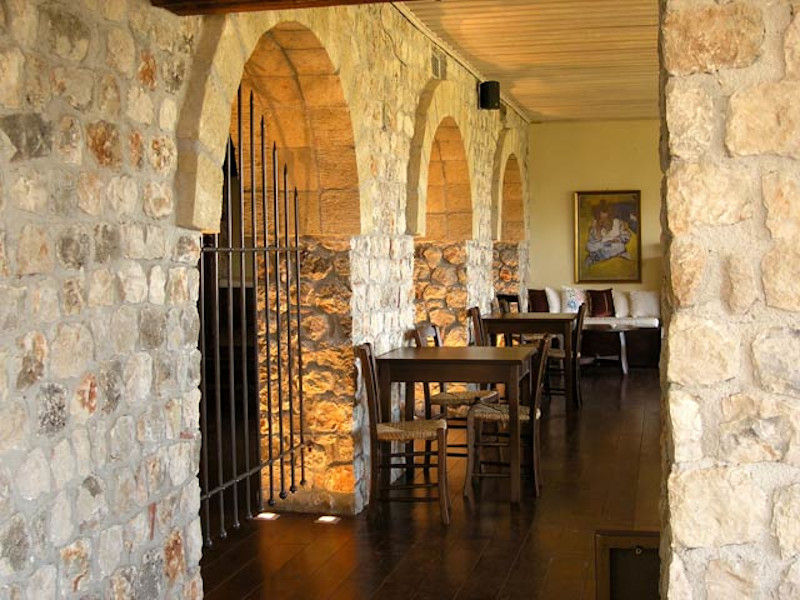 Lafkiotis Winery corridor with stone arcades and a wrought iron entrance gate on the one side