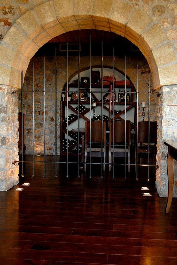 Lafkiotis Winery stone arcade and a wrought iron entrance gate