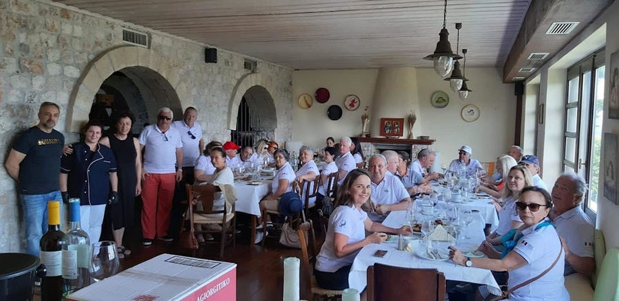 tourists smiling happily at the camera and drinking wine at Lafkiotis Winery tasting room