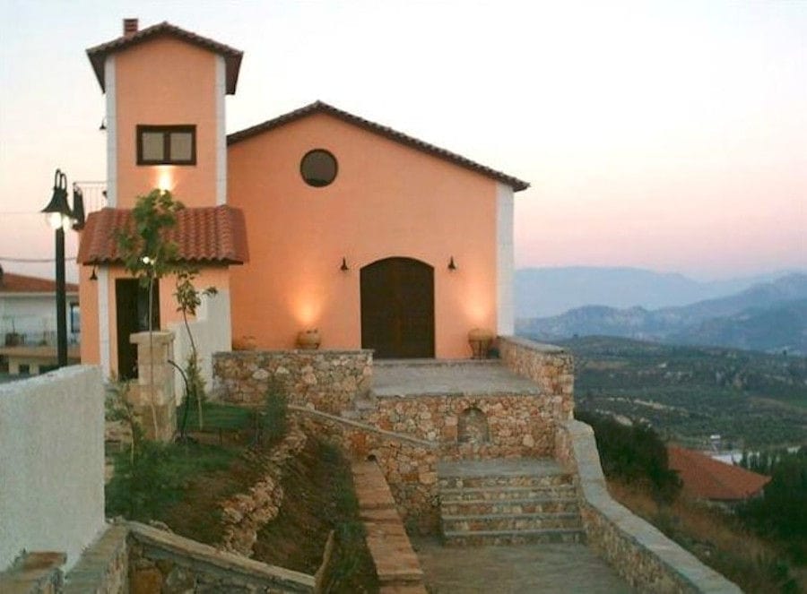 front view of Lafkiotis Winery illuminated on the both sides with stone pavement and steps in the sunset