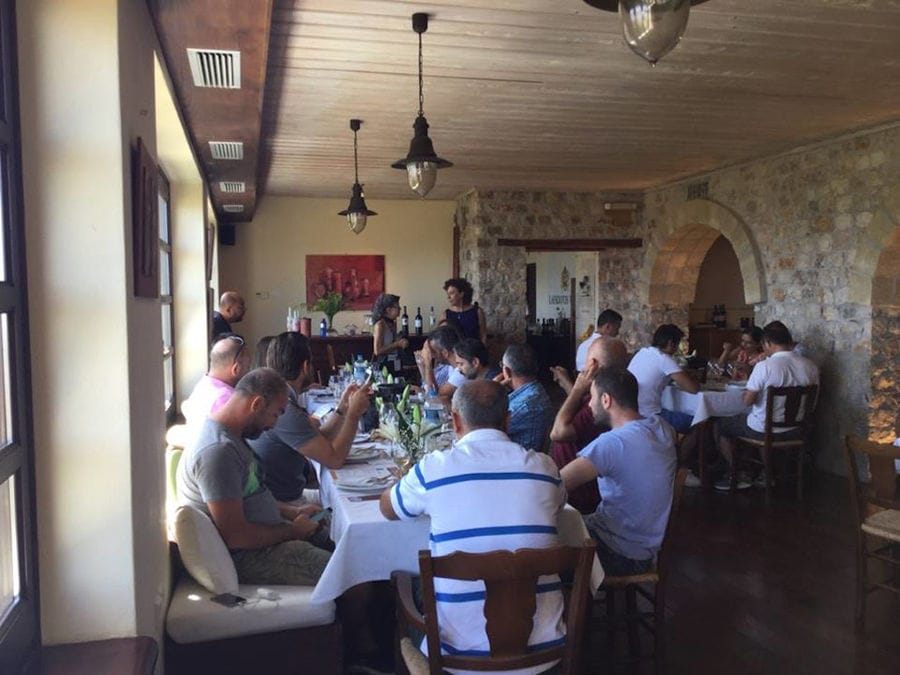 Tourists sitting at the tables and drinking wine at Lafkiotis Winery tasting room